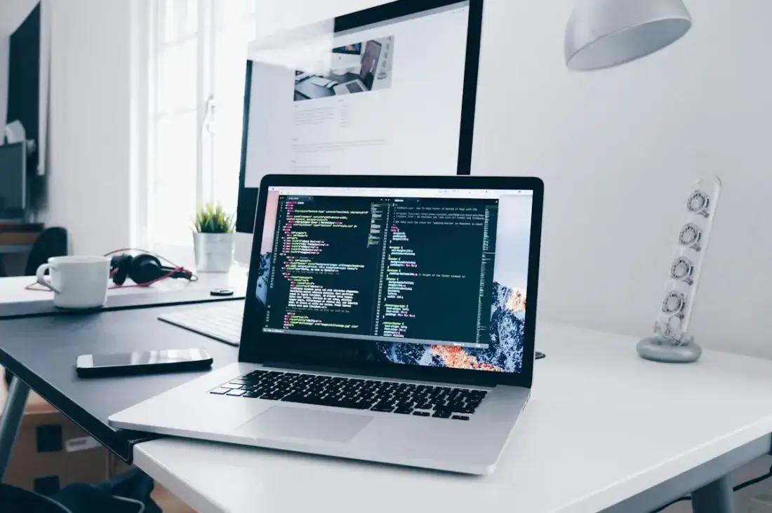 A laptop and everyday tools arranged on a real working desk