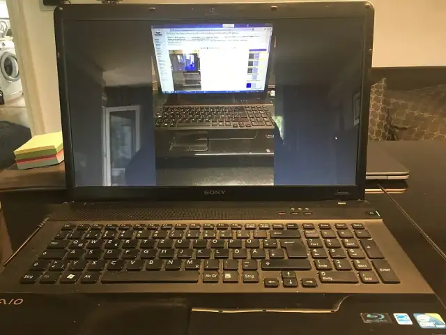 Image with nested realities of a laptop showing the image of the same laptop showing a Wikimedia Commons image of the laptop