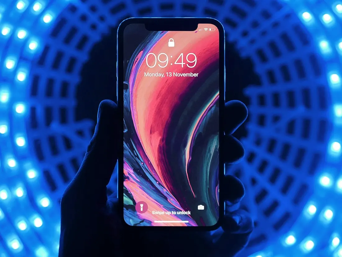 A smartphone held in front of blue lights