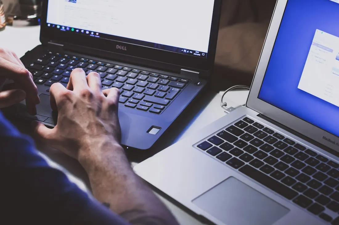Two laptops being used at a desk