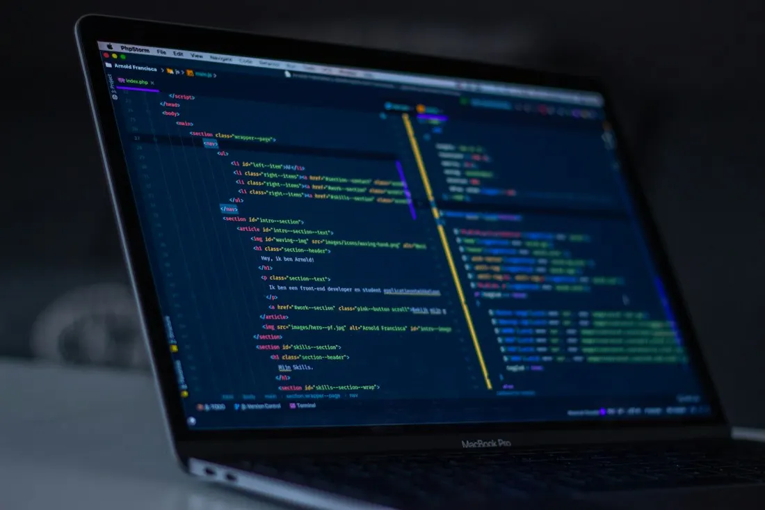 A laptop displaying software code on its screen