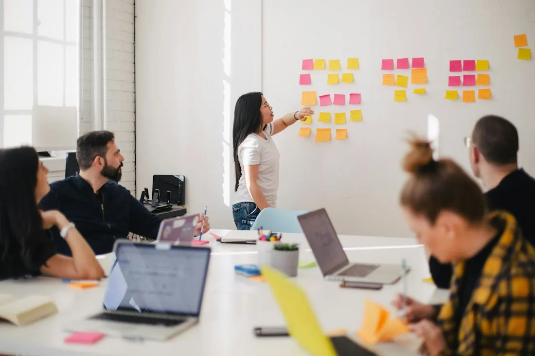 A team discussing notes on an office wall