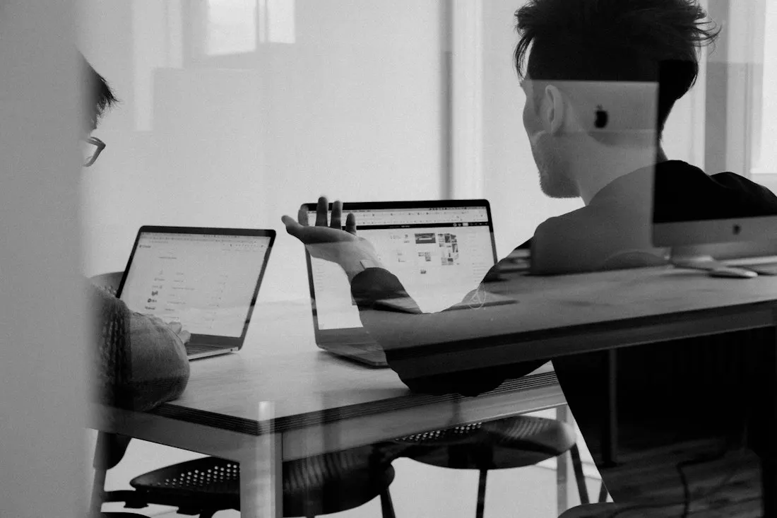 A person working at a laptop beside a tablet