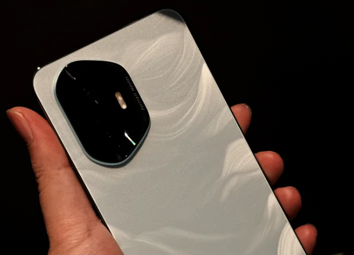 A hand holding a smartphone showing its rear panel and camera housing