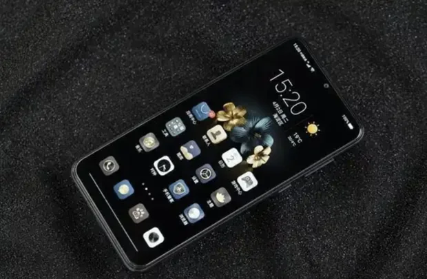 An older smartphone displaying its home screen on a dark surface