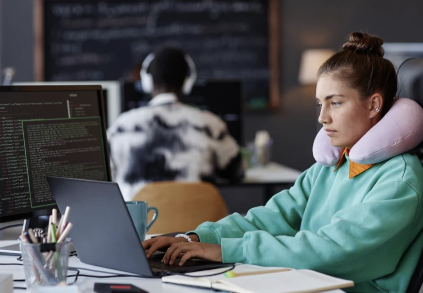 A programmer working with a laptop and an external display