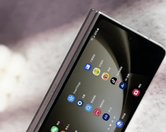 An open folding smartphone showing application icons on its display