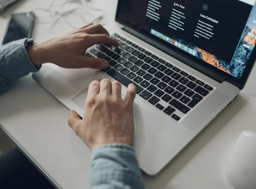 A person using the keyboard and trackpad of a laptop