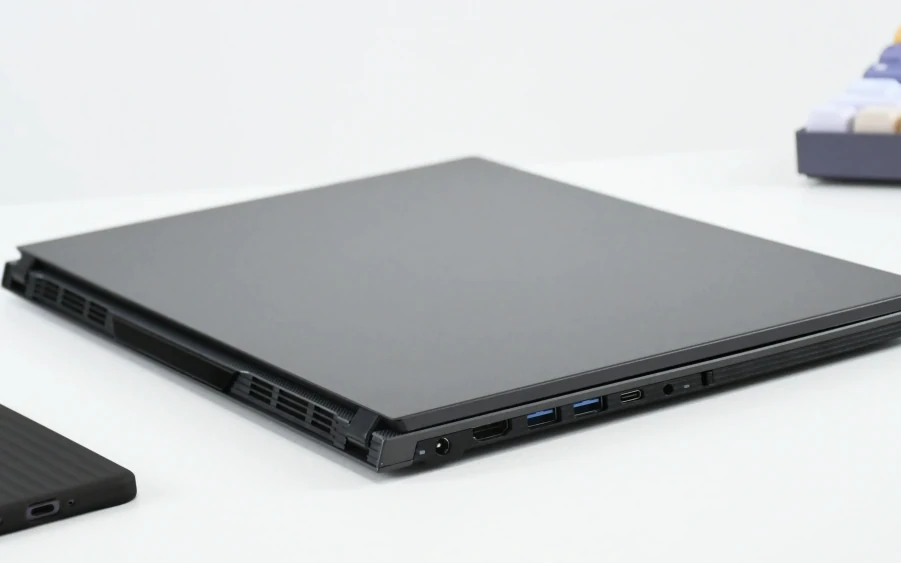 A closed laptop showing its side ports and ventilation openings