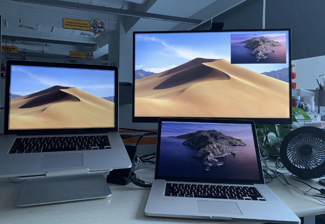 Two laptops and a large external display arranged on a desk